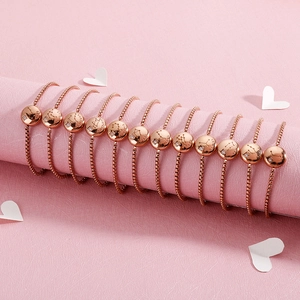Rose gold zodiac bracelets with adjustable chains displayed on a pink aesthetic stand