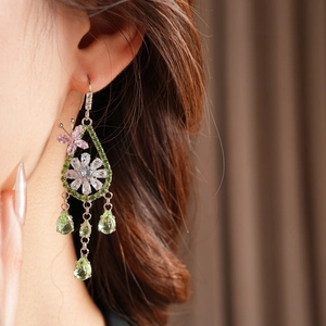 Dettaglio orecchino pendente argento con fiore rosa, zircone verde e farfalla
