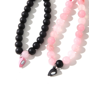Gros plan des breloques magnétiques en cœur sur les bracelets en perles pour couples
