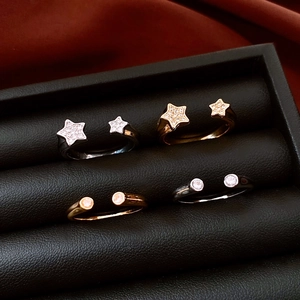 Detail of star and circular 18k gold plated rings set with cubic zirconia in a jewelry box