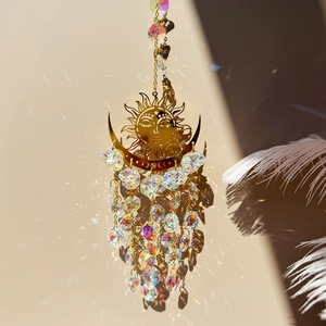 Detail of golden sun and moon suncatcher with faceted crystal beads and light refraction