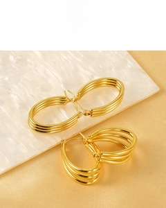Detail of 18k gold plated multi-layer hoop earrings with polished metal finish