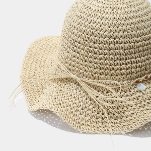 Détail du chapeau de soleil au crochet avec des perles et des pendentifs en coquillage