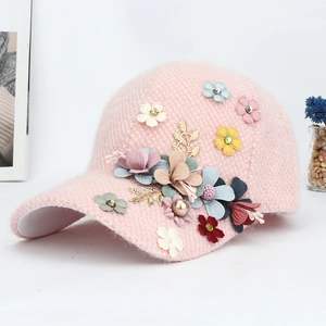 Détail d'une casquette en maille rose avec fleurs 3D, perles et strass brillants