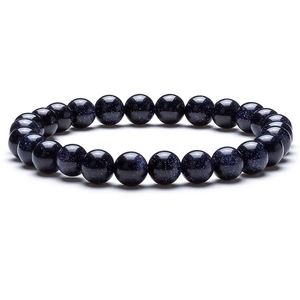 Macro detail of a sparkling deep blue sandstone bead bracelet on a white background