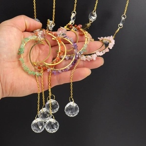 Handmade moon suncatcher with colorful crystals and gold chain hanging from a hand