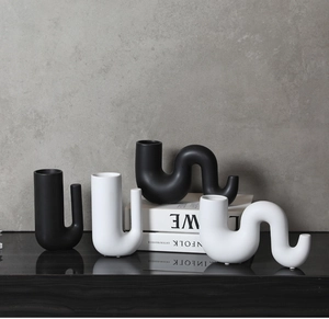 Détail de vases en céramique mate noir et blanc aux formes ondulées et minimalistes