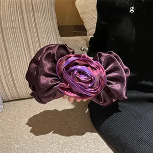 Detailed view of dark purple satin evening clutch bag with elegant rose floral design