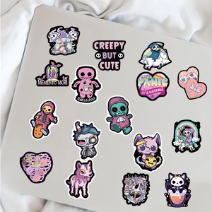 Gothic stickers with skulls and cats on a white laptop, creepy but cute style