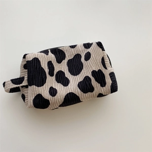 Detailed view of cow print makeup bag with textured bubble fabric and side handle