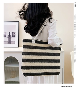 Detail of a large capacity striped woven tote bag with white rope handles for women