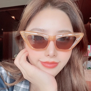 Fashionable translucent orange cat eye sunglasses with brown lenses on female model