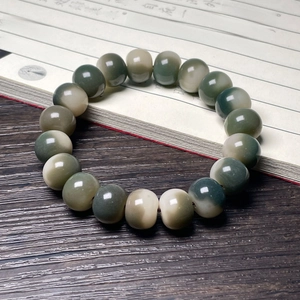 Macro detail of gradient Bodhi root beads with charcoal cat paw carving on ancient book