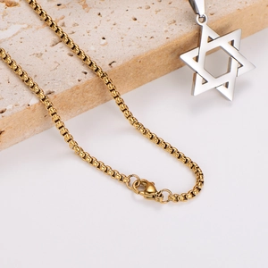 Golden mesh chain with silver hollow hexagram star pendant on stone background