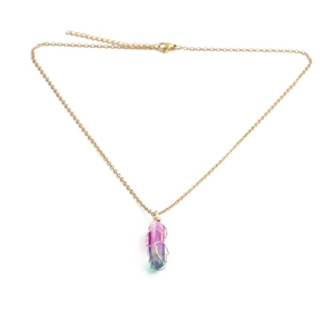Macro detail of multicolored crystal pendant wrapped in gold wire on a thin chain