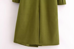 Dettaglio dell'orlo del cappotto di lana verde militare con cuciture e spacco posteriore