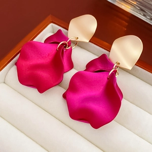 Détails des boucles d'oreilles aux plaques dorées et pétales de fleurs rouge rose