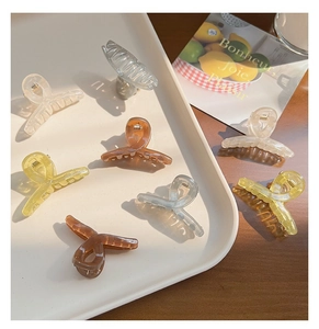 Collection of 4.5cm translucent jelly-colored claw clips neatly arranged on a white tray