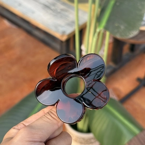 Détail de la pince à cheveux fleur écaille ambre avec finition en acrylique poli