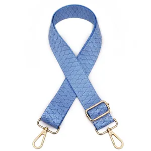 Detail of adjustable blue wave pattern fabric bag strap with gold metal hooks
