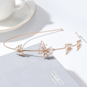 Détail du serre-tête doré avec papillons orné de perles blanches et de strass brillants
