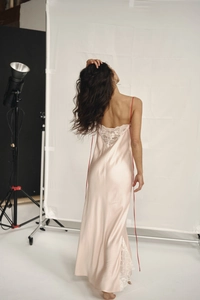 Close-up of champagne satin dress showing delicate white lace trim and elegant back detail