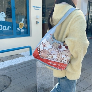 Outdoor shot of light blue canvas tote bag featuring cute cartoon dog prints