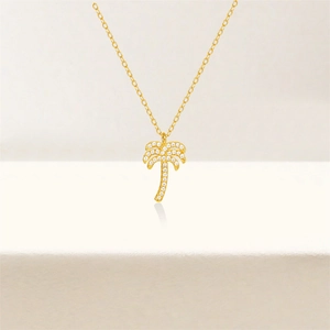 Macro detail of a gold S925 silver palm tree pendant necklace with white cubic zirconia