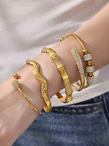 Détail de quatre bracelets en acier inoxydable plaqué or sertis de zircons 5A brillants