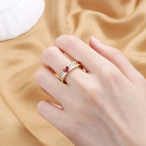 Gold-plated open ring with red heart gems and rectangular cubic zirconia on finger