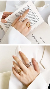 Detalle de anillos ajustables en oro y plata con líneas ovales y diseños calados de perlas