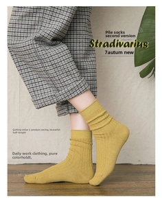 Detail of ginger yellow ribbed knit slouch socks styled with grey plaid trousers for autumn
