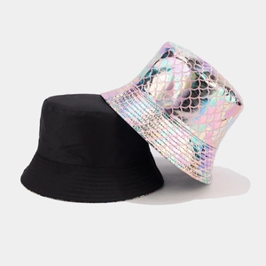 Detail of reversible bucket hat showing classic black and vibrant iridescent fish scale texture