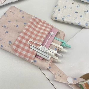 Detail view of pink floral canvas nurse pocket protector showing pens and inner storage