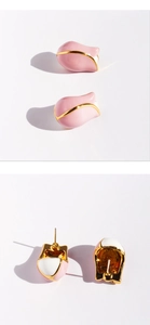 Detailed macro view showing pink enamel tulip earrings with golden edges and silver studs