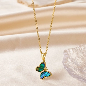 Detail view of golden butterfly necklace with turquoise shell inlay on champagne silk