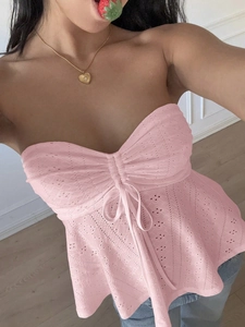 Detailed view of pink lace tube top with drawstring and hollow-out texture on model