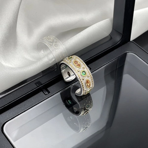 Detail of vintage palace style wide open ring with green gems and gold beaded edges