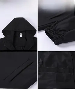 Detail view of black hooded jacket showing windproof fabric, elastic cuffs and pockets