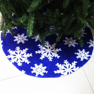 Close-up of bright blue plush Christmas tree skirt with white snowflake patterns