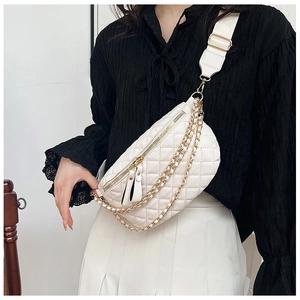 Detail shot of white quilted chest bag with golden chains and adjustable strap