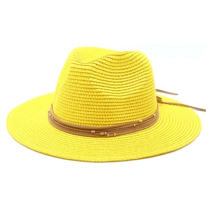 Detail of yellow fedora straw hat with brown leather bands and gold bead accents