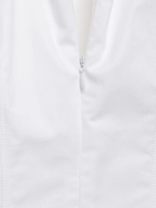 Détail d'une robe midi blanche montrant le tissu en sergé et la fermeture éclair invisible
