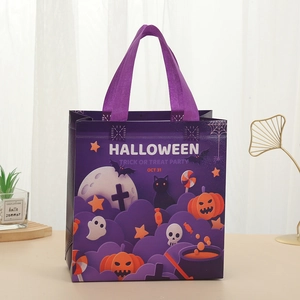 Purple Halloween non-woven gift bag with pumpkin and bat prints on a wooden table