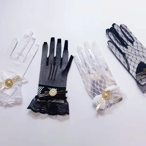 Detail of elegant mesh lace gloves with bow and pearl accents in black and white