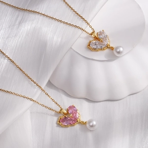 Gold-plated heart pendant necklaces with crystals and pearls on white silk