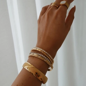 Primo piano di braccialetti in acciaio inossidabile placcati oro 18K con zirconi bianchi