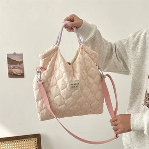 Détail du sac matelassé à fleurs et lapin avec poignées violettes et bandoulière