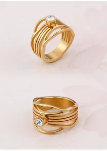 Detail of a gold fishtail hollow ring with five bands and a round clear gemstone inlay