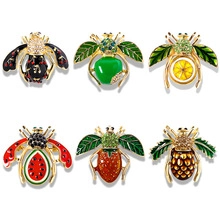 Macro detail of six-piece insect and fruit enamel brooches set with crystal rhinestones